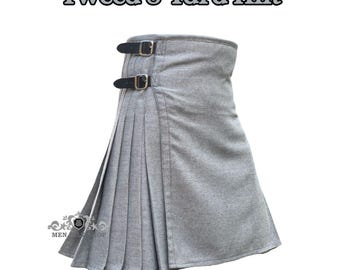 May include: A gray tweed kilt with pleats and two black leather straps with silver buckles. The kilt has the text "Tweed 8 Yard Kilt" in the upper part of the image.