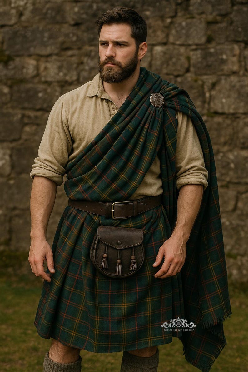 May include: A beige long-sleeved shirt paired with a green, red, and yellow plaid kilt and matching tartan plaid. The outfit includes a dark brown leather belt, a matching leather sporran with three tassels, and a circular metal brooch pin.