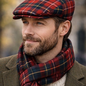 May include: A red, green, and yellow plaid flat cap paired with a matching red, green, and yellow plaid scarf. The cap features a structured crown and a short, stiff brim, while the scarf is wrapped around the neck in a simple, layered style.