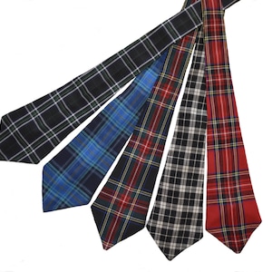 Puede incluir: Cuatro corbatas estampadas en diferentes colores y diseños. Las corbatas están dispuestas en forma de abanico, con las puntas de las corbatas apuntando hacia la parte inferior de la imagen. Las corbatas están todas hechas de tejido tejido y tienen un aspecto clásico y formal.