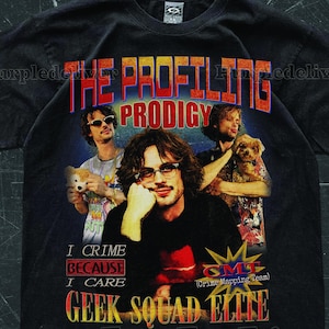 May include: Black t-shirt with a graphic of a man and the text "THE PROFILING PRODIGY." The shirt also features the phrases "I CRIME BECAUSE I CARE" and "GEEK SQUAD ELITE" in a retro style.