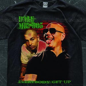 May include: Black t-shirt featuring a graphic of two men with sunglasses and the text "DALE MR. 305" in green. The phrase "EVERYBODY GET UP" is also printed on the shirt.