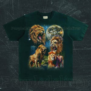 May include: Dark green t-shirt featuring a graphic of four lions with open mouths, set against a night sky with a full moon. The lions are depicted in shades of brown and orange, with detailed manes. The shirt has a classic crew neck.