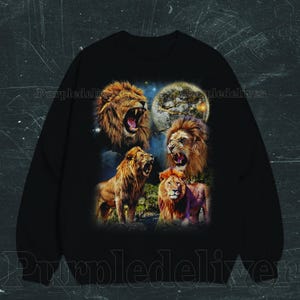May include: Black sweatshirt featuring a graphic of four lions with open mouths, a full moon, and a starry night sky. The lions are various shades of brown and tan. The sweatshirt is a crew neck style.