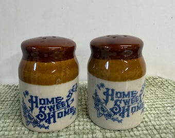 Juego de salero y pimentero Vintage Home Sweet Home con estampado floral azul y efecto goteo en tonos marrones.