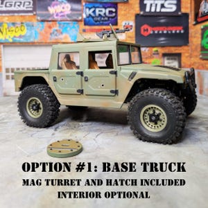 Puede incluir: Un cami&oacute;n de juguete verde oliva con neum&aacute;ticos negros y una ametralladora montada. El texto "OPTION #1: BASE TRUCK MAG TURRET AND HATCH INCLUDED INTERIOR OPTIONAL" se muestra debajo. Tambi&eacute;n se incluye una pieza circular separada.