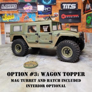 Puede incluir: Un juguete verde oliva con forma de vag&oacute;n con una ametralladora montada y neum&aacute;ticos negros grandes. El texto "OPTION #3: WAGON TOPPER MAG TURRET AND HATCH INCLUDED INTERIOR OPTIONAL" se muestra debajo del juguete.