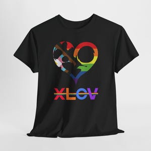 May include: Black t-shirt featuring a heart-shaped design in rainbow colors, with a section representing the transgender flag. The word "XLOV" is printed below the heart in rainbow colors. The shirt is made of a soft material.