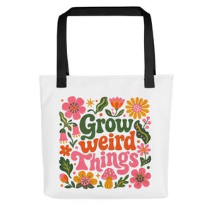 Könnte beinhalten: Eine weiße Tragetasche mit schwarzen Henkeln und einem farbenfrohen Grafikdruck mit dem Schriftzug Grow weird Things in stilisierter Schrift, umgeben von verschiedenen Illustrationen von Blumen, Blättern und einem kleinen Pilz in Rosa, Orange und Grün.