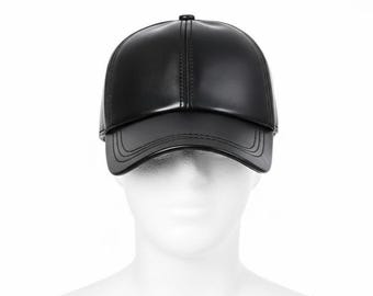 May include: A black baseball cap made of a smooth, shiny material. The cap has a curved brim and a rounded crown. The cap is displayed on a white mannequin head.