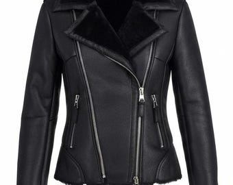 May include: Black faux leather jacket with a shearling collar and lining. The jacket features a diagonal zipper closure, multiple zippered pockets, and shearling trim on the cuffs. A stylish outerwear piece.
