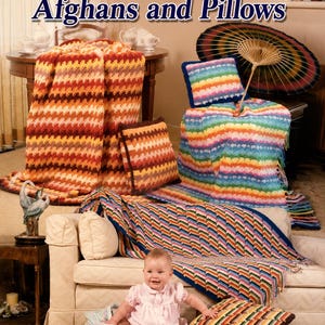Può includere: Una collezione di coperte e cuscini all'uncinetto con motivi geometrici in varie palette di colori, inclusi toni caldi dell'arancione, strisce arcobaleno e disegni sui toni del blu, con il testo Optical Illusion Afghans and Pillows.