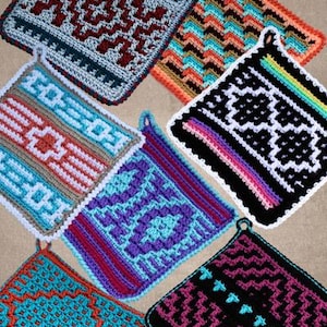 May include: A selection of square crochet potholders with geometric designs. Each potholder displays a unique pattern, including zigzags and diamond shapes. The potholders are in a variety of colours, such as blue, orange, black, and purple. They have hanging loops.