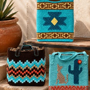 May include: Three handmade crochet bags in turquoise, brown, and tan. The bags feature geometric and Southwestern-inspired patterns. One bag has a cat and cactus design. The bags are displayed on a wooden surface.