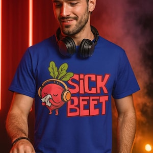 May include: A blue t-shirt with the text "SICK BEET" in red. The shirt features a cartoon beet wearing headphones. The person in the image is wearing black headphones around their neck.