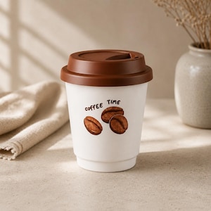 May include: A white reusable coffee cup with a brown lid. The cup features a graphic of three brown coffee beans and the text "coffee TIME" printed in a dark brown font on the front. The cup has a smooth finish and a tapered cylindrical shape.