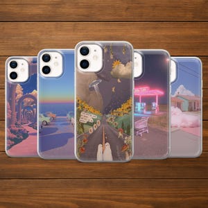Pode incluir: Cinco capas de telefone transparentes com vários designs. Uma capa apresenta uma estrada com fantasmas, um alienígena e texto. Outra mostra um posto de gasolina. Outras capas exibem paisagens surreais com carros e arcos.