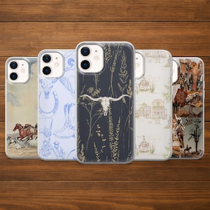 Könnte beinhalten: Fünf Handyhüllen mit Western-Motiven werden auf einer Holzoberfläche präsentiert. Die Hüllen zeigen Illustrationen von Pferden, Cowboy-Stiefeln, einem Longhorn-Schädel und einer Wüstenlandschaft. Die Hüllen haben eine transparente Schutzhülle.