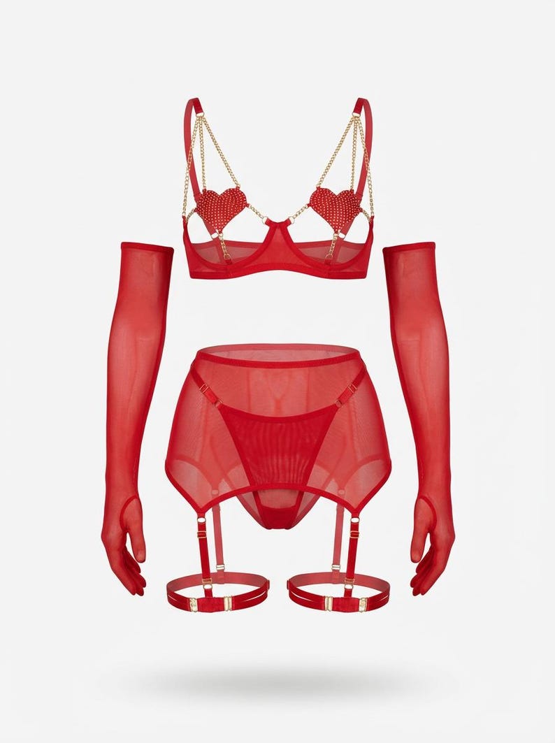 May include: A red lingerie set featuring a bra with heart-shaped embellishments and gold chain straps, a garter belt, a thong, and sheer gloves. The set is made of a sheer, lightweight fabric. The bra has underwire support.