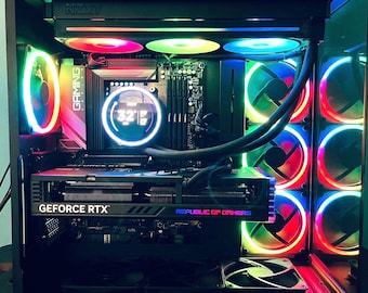 May include: A desktop computer tower with a transparent side panel, featuring internal components illuminated by multi-colored RGB lighting. The system includes a liquid cooling unit with an NZXT logo, a GeForce RTX graphics card, and multiple fans.