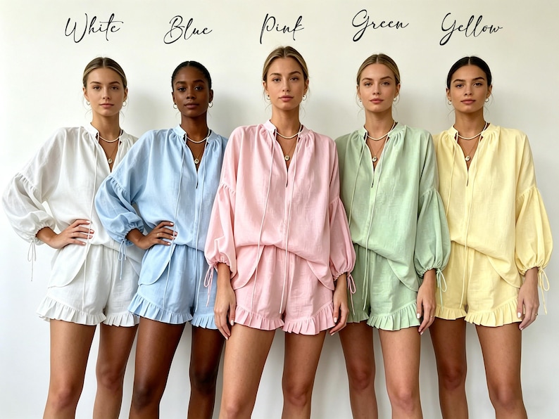 May include: Five women modeling matching pajama sets in white, blue, pink, green, and yellow. Each set includes a long-sleeved top with a drawstring neckline and shorts with a ruffled hem. The word "White", "Blue", "Pink", "Green", and "Yellow" are written above each woman.