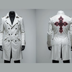 May include: A white double-breasted trench coat with black buttons and a decorative red and black cross design on the back. The coat has a classic collar, pockets, and long sleeves. The coat is displayed on a mannequin.