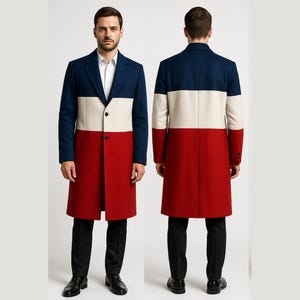 Op de afbeelding: Een lange jas met een colorblock-ontwerp in marineblauw, crème en rood. De jas heeft een sluiting met één knoop en een klassieke revers. Het model draagt een zwarte broek en zwarte schoenen. De jas is ongeveer 127 cm lang.