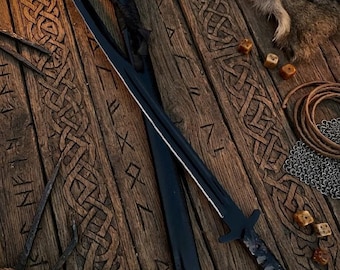 May include: A black metal sword with a pointed blade and a crossguard, accompanied by a matching black scabbard. The sword features a textured handle and a sharp edge, presented alongside a black sheath with a leather strap attachment.