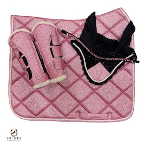Puede incluir: Una mantilla de silla acolchada de color rosa con purpurina, dos protectores de patas a juego de color rosa con purpurina y forro polar blanco, y una orejera negra con ribete de pedrería rosa. Incluye el texto BEST HORSE Premium Equestrian Gear.