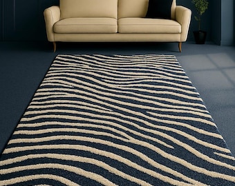 May include: A rectangular rug with a navy blue background and beige, wavy stripes. The rug is placed in front of a beige sofa and a dark blue wall. The rug's design adds a modern touch to the room.