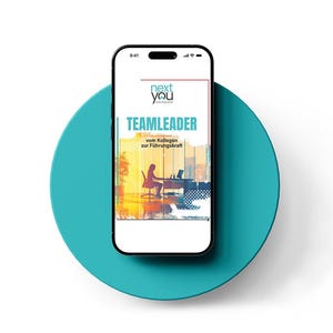 May include: A smartphone screen shows a book cover with the title "TEAMLEADER" in blue and white. The cover features a silhouette of a person at a desk, with the text "vom Kollegen zur Führungskraft" below. The phone is on a teal circular surface.
