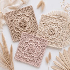 Può includere: Tre sottobicchieri quadrati all'uncinetto con complessi motivi floreali a mandala in tonalità beige, marrone chiaro e rosa antico. Ogni pezzo presenta un motivo circolare centrale circondato da punti dettagliati, creando un design strutturato.