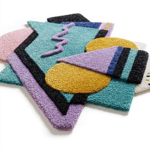Pode incluir: Uma cole&ccedil;&atilde;o de tapetes geom&eacute;tricos coloridos em v&aacute;rias formas. Os tapetes apresentam uma mistura de cores, incluindo azul-petr&oacute;leo, roxo, amarelo, rosa e preto. Os designs incluem tri&acirc;ngulos, c&iacute;rculos e um padr&atilde;o em zigue-zague, criando uma est&eacute;tica vibrante e moderna.