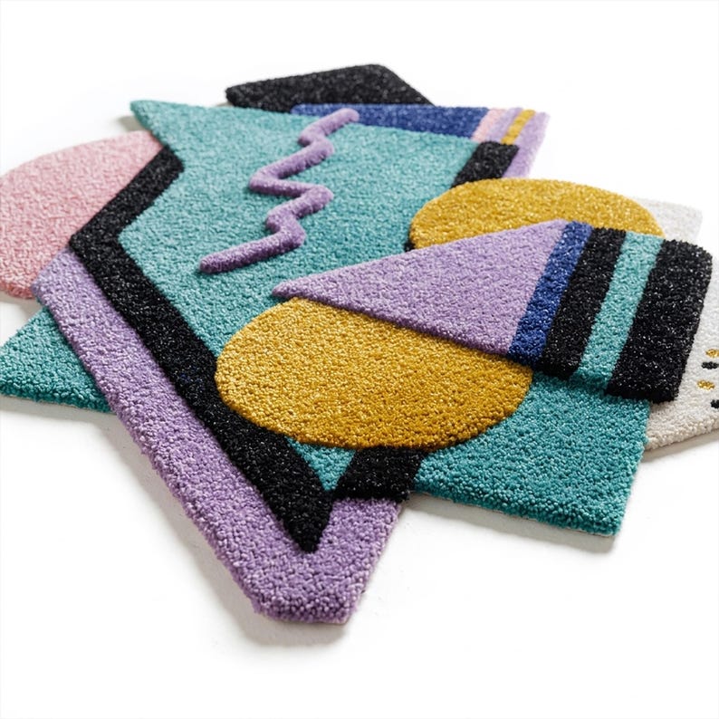 Pode incluir: Uma cole&ccedil;&atilde;o de tapetes geom&eacute;tricos coloridos em v&aacute;rias formas. Os tapetes apresentam uma mistura de cores, incluindo azul-petr&oacute;leo, roxo, amarelo, rosa e preto. Os designs incluem tri&acirc;ngulos, c&iacute;rculos e um padr&atilde;o em zigue-zague, criando uma est&eacute;tica vibrante e moderna.