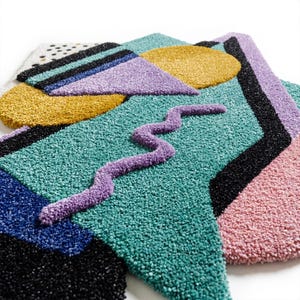 Pode incluir: Um tapete abstrato colorido com formas geom&eacute;tricas e uma superf&iacute;cie texturizada. O tapete apresenta uma base turquesa com uma linha ondulada roxa, um c&iacute;rculo amarelo e detalhes em preto, azul e rosa. Uma pe&ccedil;a &uacute;nica de decora&ccedil;&atilde;o para casa.