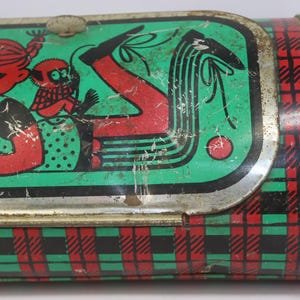 May include: Vintage metal lunchbox with a green, red, and black plaid pattern. The lid features a cartoon illustration of a girl with a monkey, in red and black on a green background. The lunchbox has a silver metal clasp.