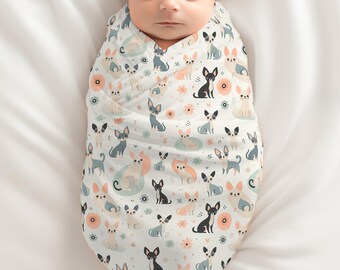 May include: A newborn baby swaddled in a white swaddle blanket with a pattern of colorful cartoon dogs. The baby is sleeping peacefully with their eyes closed.