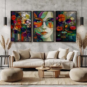May include: Three framed art prints. The left print features colorful circles and lines. The center print is a portrait of a woman wearing sunglasses. The right print depicts flowers and water lilies. The prints are above a beige sofa.