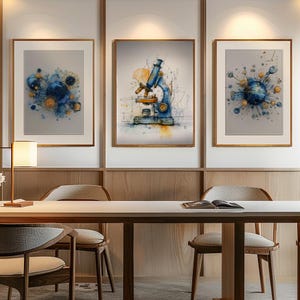 May include: Three framed art prints. The central print shows a blue and yellow watercolour illustration of a microscope. The other two prints depict abstract watercolour designs in blue, yellow, and white. The frames are brown.