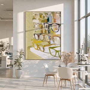 May include: A framed wall art print featuring a watercolor-style illustration of multiple pairs of eyeglasses in various colors including yellow, green, brown, and black, arranged in rows against a light yellow background with faint script text.