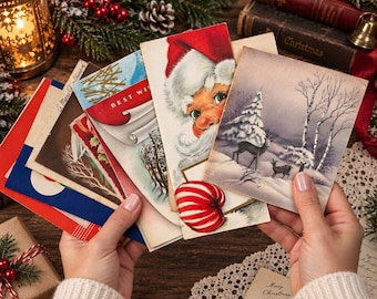 May include: A collection of vintage Christmas greeting cards featuring various holiday illustrations including a portrait of Santa Claus, a snowy forest scene with deer, and red and white candy cane motifs, all displayed in a layered fan arrangement.