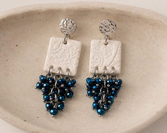 Pendientes hechos a mano de arcilla blanca y cristal azul