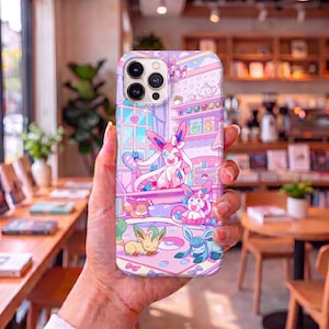 May include: A smartphone case featuring a colorful illustration of various Eevee evolution characters in a room setting. The design includes Sylveon, Leafeon, Glaceon, and Eevee in shades of pink, purple, and blue with small heart and bow motifs.