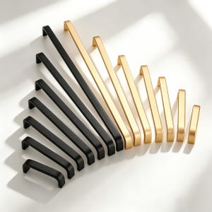 Könnte beinhalten: Eine Auswahl an Schrankgriffen in verschiedenen Größen und Stilen. Die Griffe sind fächerförmig angeordnet und haben schwarze und goldene Oberflächen. Die Hardware besteht aus Metall und hat ein modernes, minimalistisches Design, das für Küchen- oder Badezimmerschränke geeignet ist.