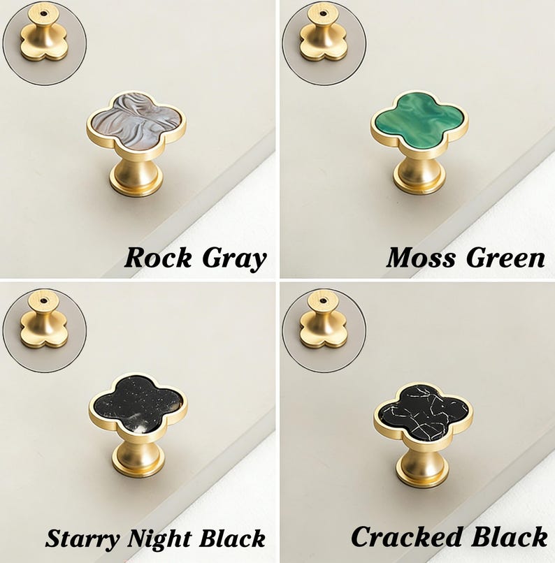 K&ouml;nnte beinhalten: Vier Schrankkn&ouml;pfe in Rock Gray, Moss Green, Starry Night Black und Cracked Black. Jeder Knopf hat eine kleeblattf&ouml;rmige Oberseite mit dekorativem Finish und eine goldfarbene Basis. Der Text darunter zeigt die Farbe an.