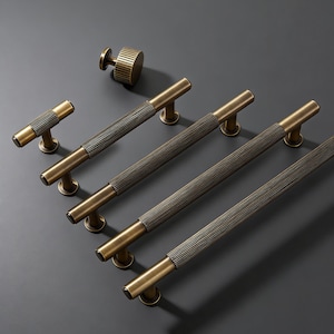 May include: A white ceramic mug with a black handle and the text "But First, Coffee" in a black, handwritten-style font. The mug is on a white surface.