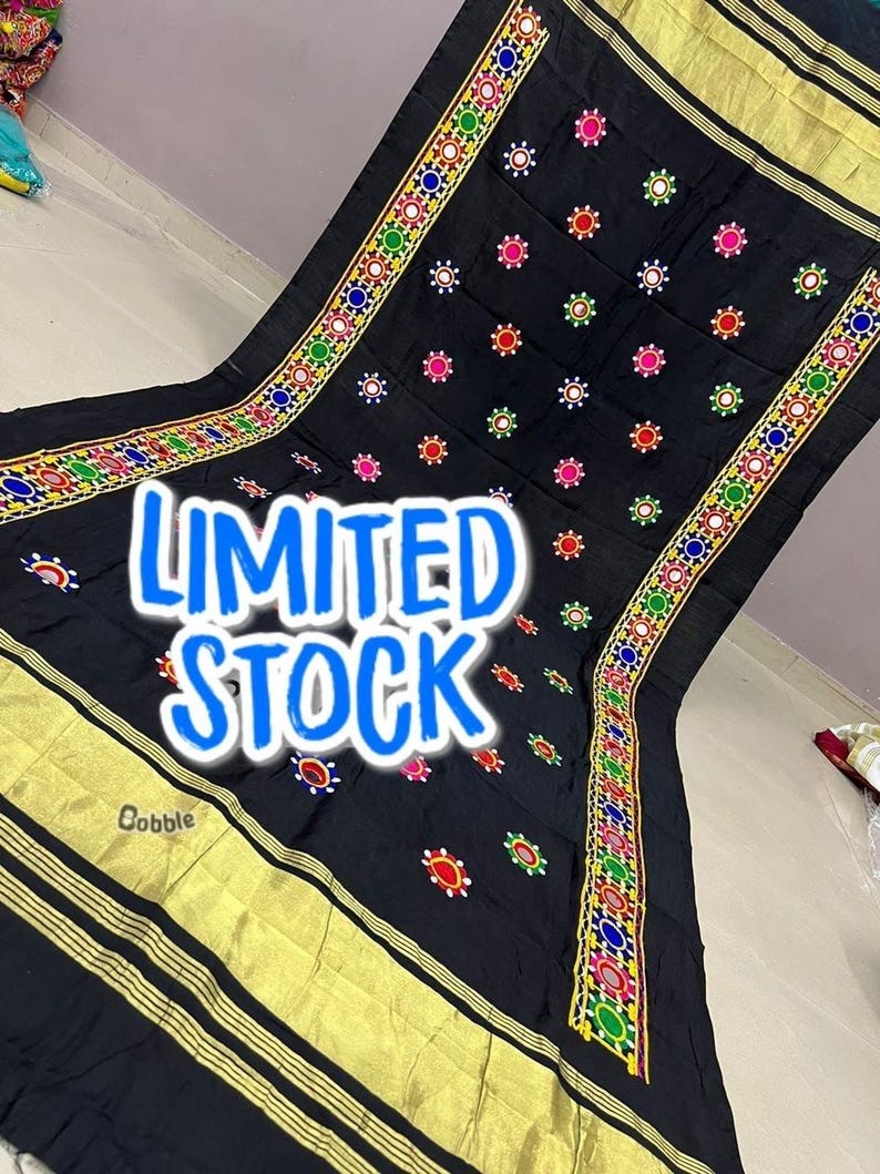 May include: Black textile with gold trim and colourful embroidered details. The textile features a repeating pattern of small, colourful embroidered circles. The words "LIMITED STOCK" are displayed in large, blue, outlined letters.