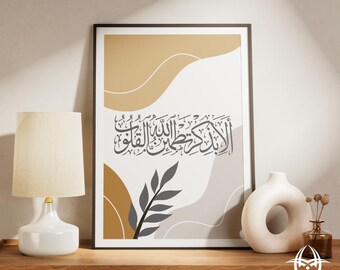 May include: Framed art print featuring Arabic calligraphy in black against a backdrop of beige, gray, and brown abstract shapes. A gray leaf design is also included. The print is displayed on a wooden surface.