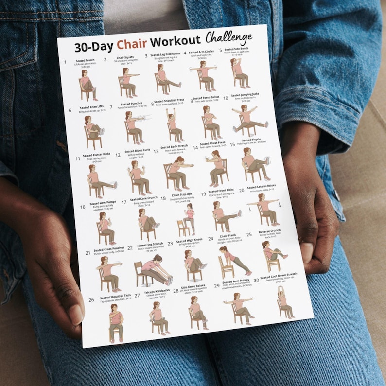 May include: A white poster titled "30-Day Chair Workout Challenge" held by a person wearing a denim jacket. The poster features illustrations of exercises performed while seated in a chair, with numbered steps and exercise names.