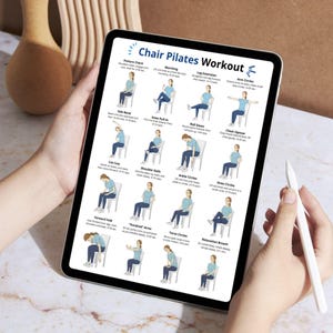 K&ouml;nnte beinhalten: Ein digitales Tablet zeigt einen "Chair Pilates Workout" -Leitfaden. Der Leitfaden enth&auml;lt illustrierte &Uuml;bungen mit Anweisungen. Das Tablet wird von einer Person gehalten, und ein wei&szlig;er Stift ist sichtbar. Der Hintergrund ist eine hellbraune Oberfl&auml;che.